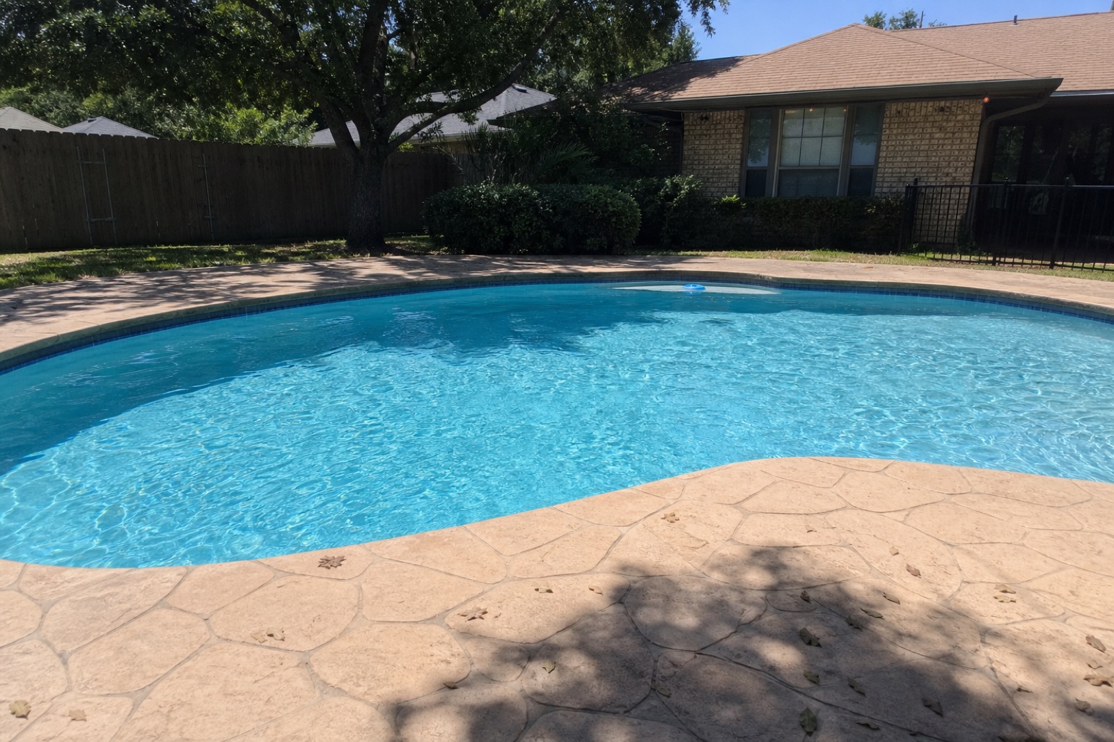 Residential backyard pool on stamped concrete deck, Fort Worth neighborhood.